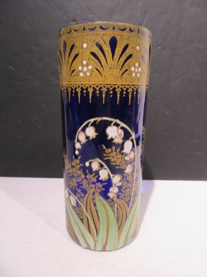 a blue vase with gold decoration on it on a table