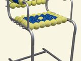 une chaise fabriquée à partir de balles de tennis montées sur une armature métallique