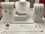 many necklaces and bracelets displayed on display in a glass case