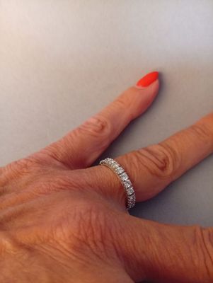 a woman ' s hand with a diamond ring on it