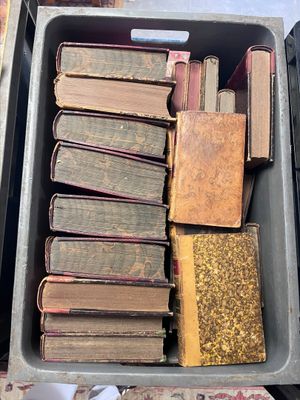 many old books in a metal box on the floor