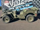 une jeep militaire garée devant un camion d'époque