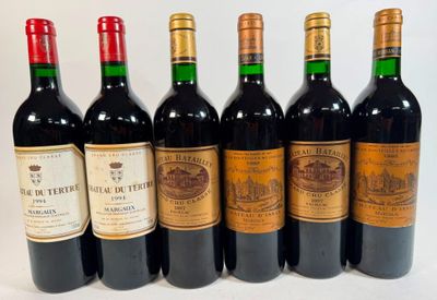 six bottles of wine are lined up in a row on a white surface