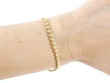 someone is wearing a bracelet with a gold bead on it
