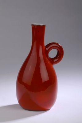 a red vase that is sitting on a white surface