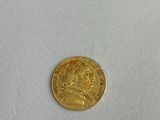 a close up of a gold coin on a white surface