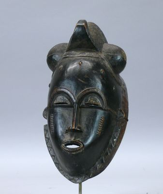 image d'un masque en bois sur un support sur fond blanc
