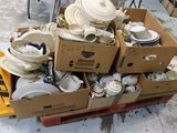 de nombreuses caisses de vaisselle blanche et de bols posées sur une palette