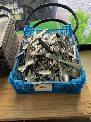 a basket full of forks and spoons on a table