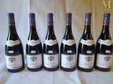 six bottles of wine are lined up in a row on a table