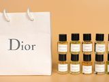 six flacons de parfum Dior devant un sac blanc