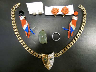 un collier, un bracelet, une bague et d'autres bijoux posés sur une table