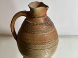 a brown vase sitting on top of a glass table