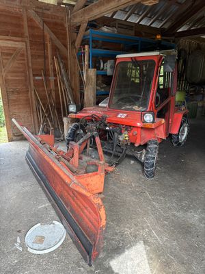 un tracteur rouge équipé d'une charrue