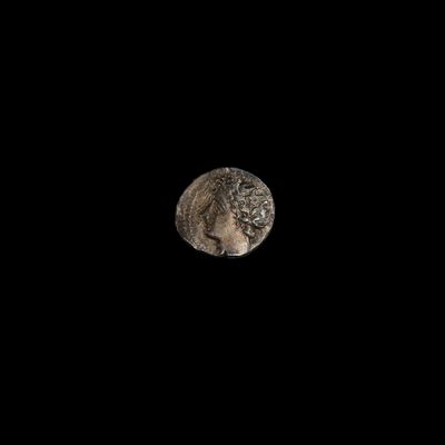 un hibou perché sur un rocher dans l'obscurité, avec la pleine lune en arrière-plan