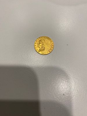 gros plan d'une pièce d'or sur une surface blanche
