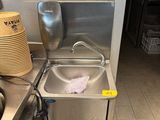 un évier de cuisine avec beaucoup de vaisselle sur le plan de travail