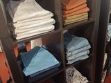 de nombreuses serviettes pliées sur une étagère dans un magasin