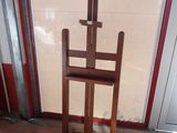 a wooden easel sitting in front of a glass door