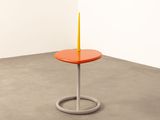a small table with a candle on it in a room