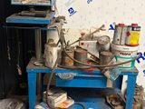 une table bleue sur laquelle sont posés de nombreux objets, devant un mur