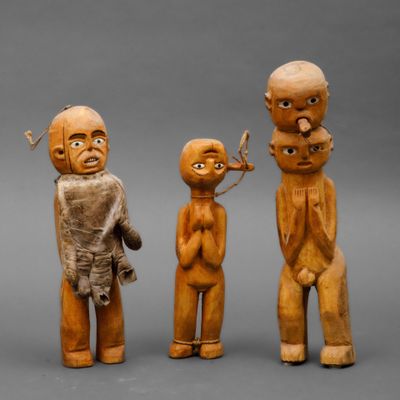 three wooden figurines of three men and a woman