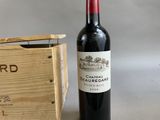 a bottle of red wine next to a wooden box