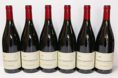 six bouteilles de vin rouge alignées sur une surface blanche