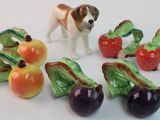 several figurines of dogs and fruits on a white surface