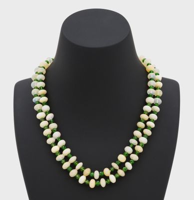 un collier de perles vertes et blanches sur un mannequin