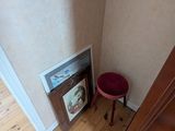 une petite table avec un tabouret rouge près d'une porte