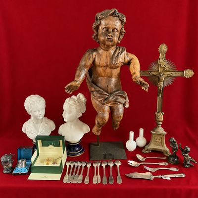 a statue of a child on a table with silverware and other items