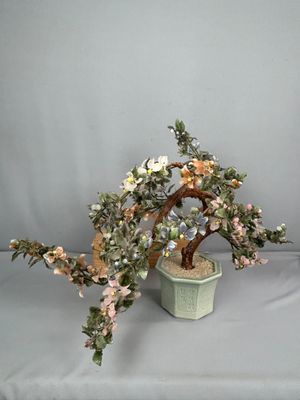 un bonsaï fleuri dans un pot, posé sur une table