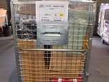 une cage métallique sur laquelle est accrochée une pancarte, dans un entrepôt