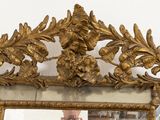 a mirror with a gold frame on the wall
