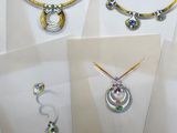 four different types of jewelry displayed on display in a display case