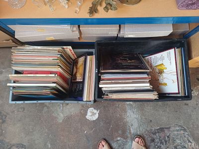 une personne debout devant une table couverte de livres