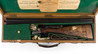 un vieux pistolet dans un coffret en bois sur lequel est collée une étiquette