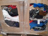 a cardboard box with clothes in it sitting on a pallet
