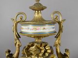 a gold and blue vase sitting on top of a table