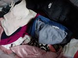 a pile of clothes sitting on top of a bed