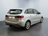 the rear end of a silver car in a white room