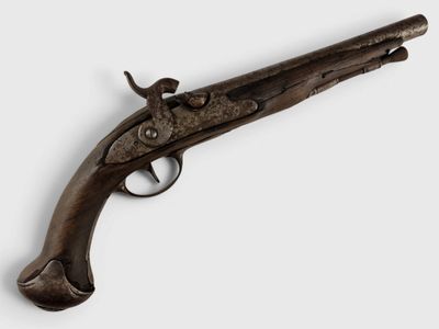 un vieux fusil avec une poignée en bois sur fond blanc