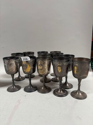 Plusieurs gobelets et tasses en argent sont alignés sur une table