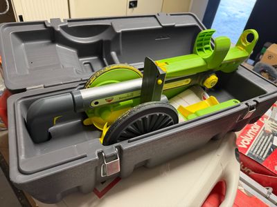 a tool box with a green machine inside of it