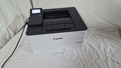 une imprimante posée sur un support et équipée d'une télécommande