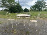 four chairs and a table on the gravel road