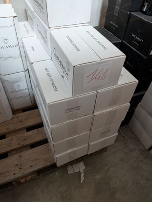 several boxes of wine are stacked on pallets in a warehouse