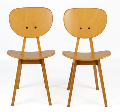 two wooden chairs with faces on the back of them