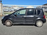 une petite voiture noire garée devant un portail